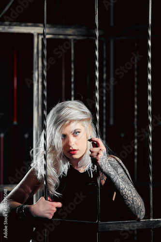 blonde with a tattoo in an iron cage, BDSM games