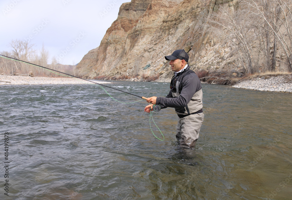 Fly fisherman casting for steelhead trout on the Salmon River in Idaho Fly fisherman casting for steelhead trout on the Salmon River in Idaho