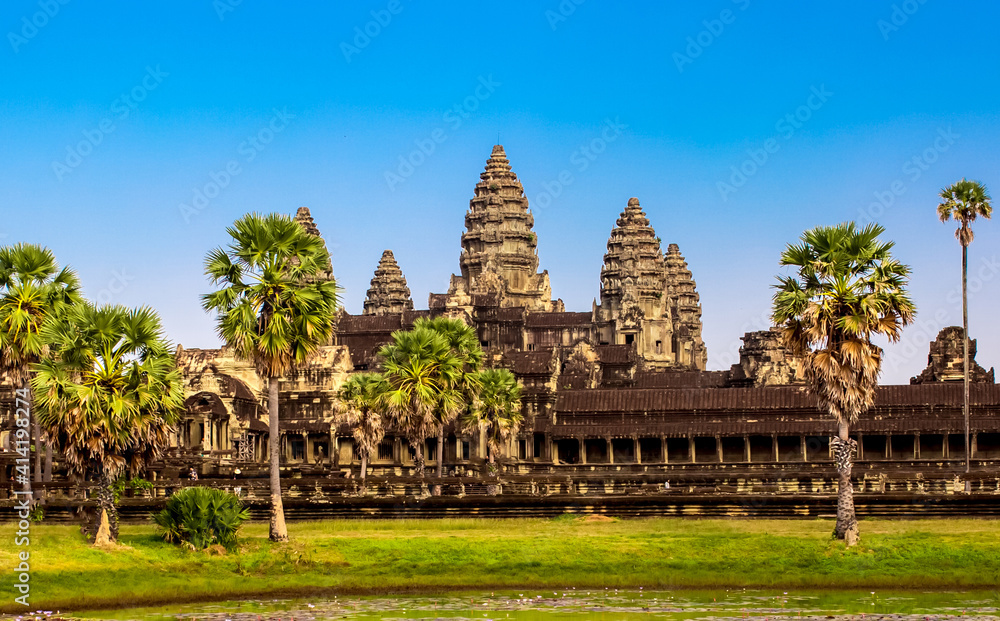 Naklejka premium Beautiful landscape of the ancient city of Angkor Wat in Cambodia. Towers of the temple of the Kmer people with reflection in the lake. The concept of travel to the sights of ancient civilizations.