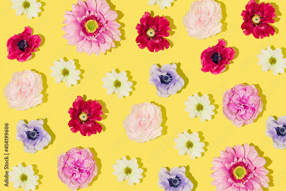 Creative pattern made with yellow, orange, rose, raspberry red, pink, purple and dark blue flowers on bright yellow background. Minimal flat lay. Creative arrangement with bloom. Spring aesthetic Creative pattern made with yellow, orange, rose, raspberry red, pink, purple and dark blue flowers on bright yellow background. Minimal flat lay. Creative arrangement with bloom. Spring aesthetic