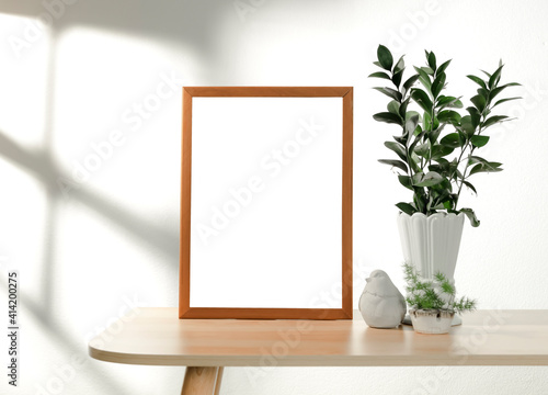 Frame or Poster mock up in living room and plants in vase with window shadow on white wall background.