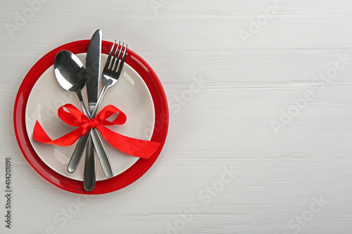 Beautiful table setting on white wooden background, top view with space for text. Valentine's Day dinner
