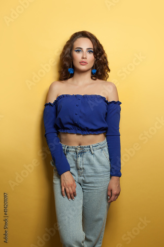 Casual fashion model woman posing on yellow background