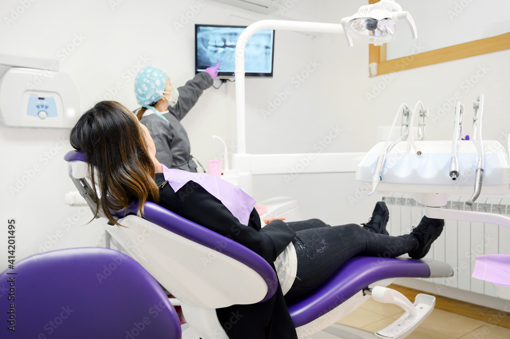 Φωτογραφία Health care concept - Female dentist showing x ray results on monitor to woman patient at dental clinic office