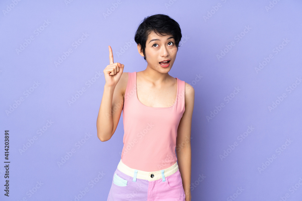 Young Vietnamese woman with short hair over isolated purple background intending to realizes the solution while lifting a finger up Young Vietnamese woman with short hair over isolated purple background intending to realizes the solution while lifting a finger up