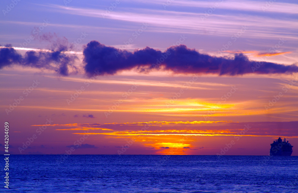 Sunset over the Atlantic Ocean with cruise ship in Sint Maarten.