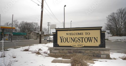 A wide shot view of the Welcome to Youngstown sign as traffic passes by on a winter overcast day.
 photo