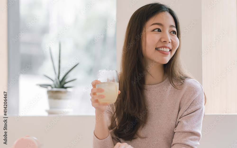 Asian woman drinking juice and resting at home Asian woman drinking juice and resting at home