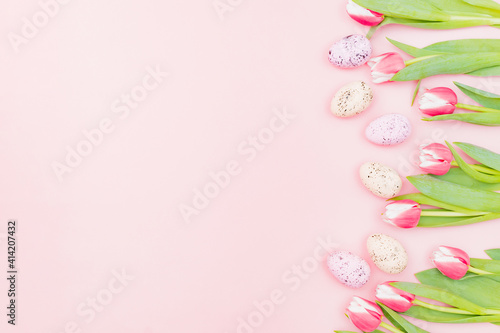 Flat lay easter composition with pink tulips and eggs on pink background