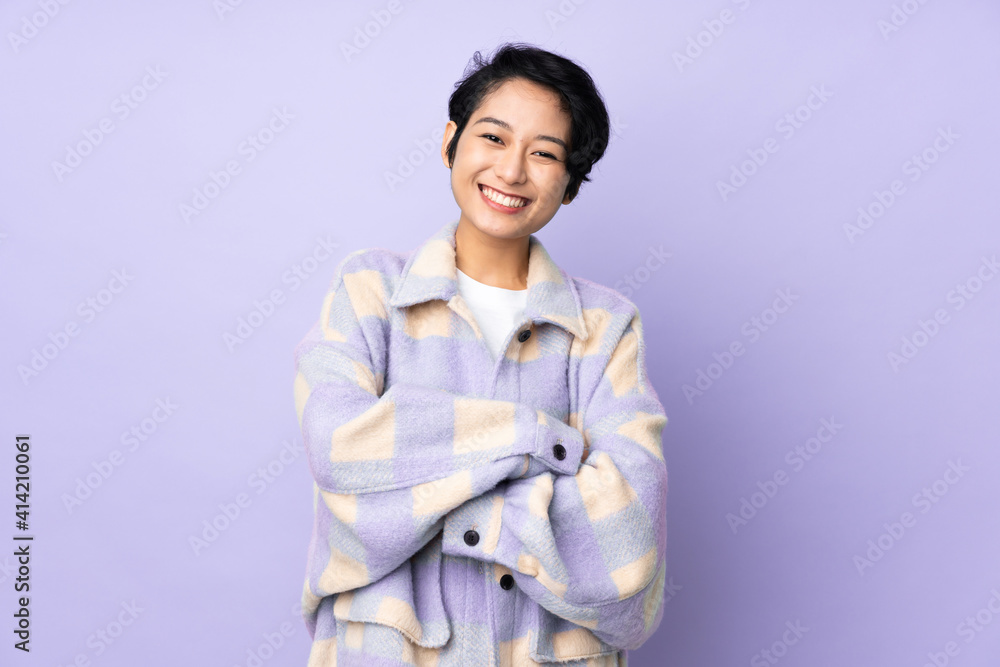 Young Vietnamese woman with short hair over isolated background keeping the arms crossed in frontal position Young Vietnamese woman with short hair over isolated background keeping the arms crossed in frontal position