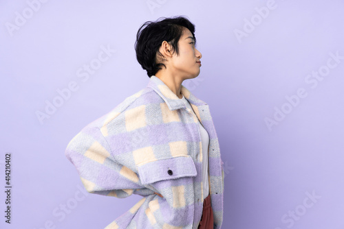 Young Vietnamese woman with short hair over isolated background suffering from backache for having made an effort