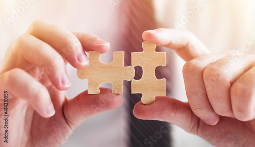 Businessman hand connecting jigsaw puzzle.Business solutions, success and strategy concept.