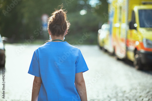 modern medical doctor woman outside near ambulance walking photo