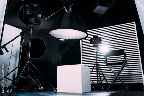 Black room cyclorama. Modern photo studio with professional equipment. Empty photo studio with lighting equipment. Interior of modern photo studio with director production chair.