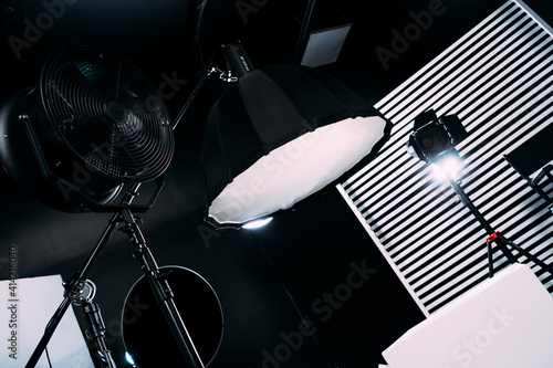 Black room cyclorama. Modern photo studio with professional equipment. Empty photo studio with lighting equipment. Interior of modern photo studio with director production chair.