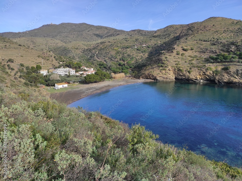 Vista de Cala Jòncols, lejana playa entre Roses y Cadaqués, rodeada de montañas y colinas rocosas. 