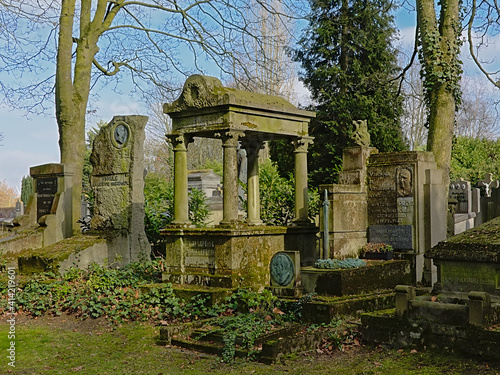 Old grave tombs in between trees in Westerbegraafplaats cemetery, Ghent, Flanders, Belgium 