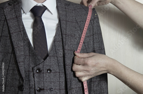 Mid section portrait of tailor fitting bespoke suit to model