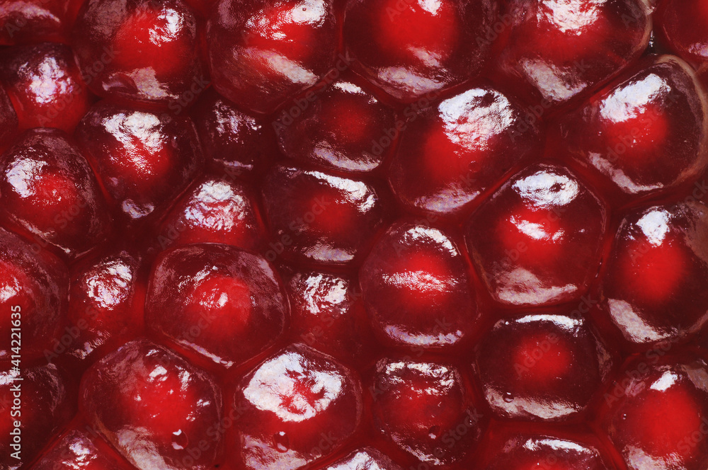 grains of ripe pomegranate close-up. Red background grains of ripe pomegranate close-up. Red background