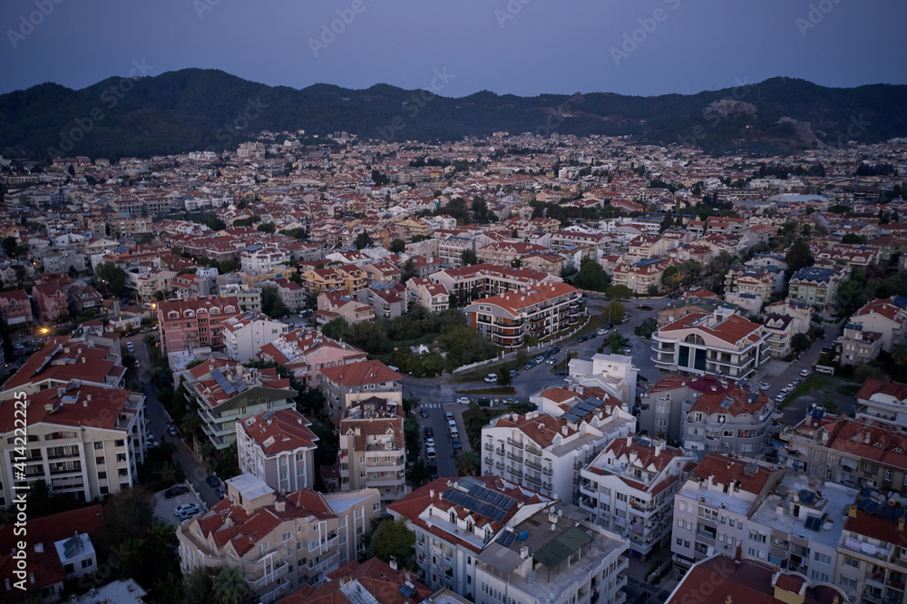 Aerial view of resort town of Marmaris, Turkey. City buildings surrounded by mountains. Scenic evening landscape.