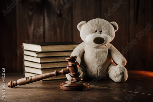 Divorce and alimony concept. Wooden gavel and teddy bear as symbol of child. photo