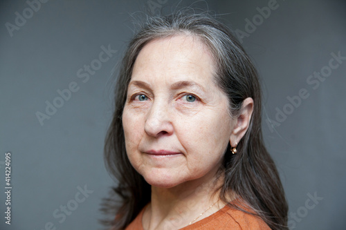 Senior woman in studio isolated on grey wall serious