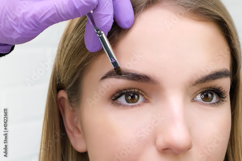 Young woman shaping eyebrows with brush