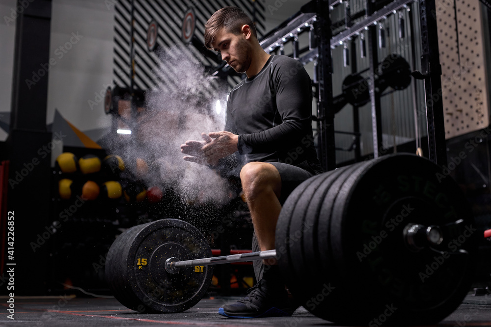 Muscular sportsman going to do squats exercise with barbell. Cross fit training in gym. Young male on sport, want to have strong powerful body, exercising with heavy weights. sport Muscular sportsman going to do squats exercise with barbell. Cross fit training in gym. Young male on sport, want to have strong powerful body, exercising with heavy weights. sport