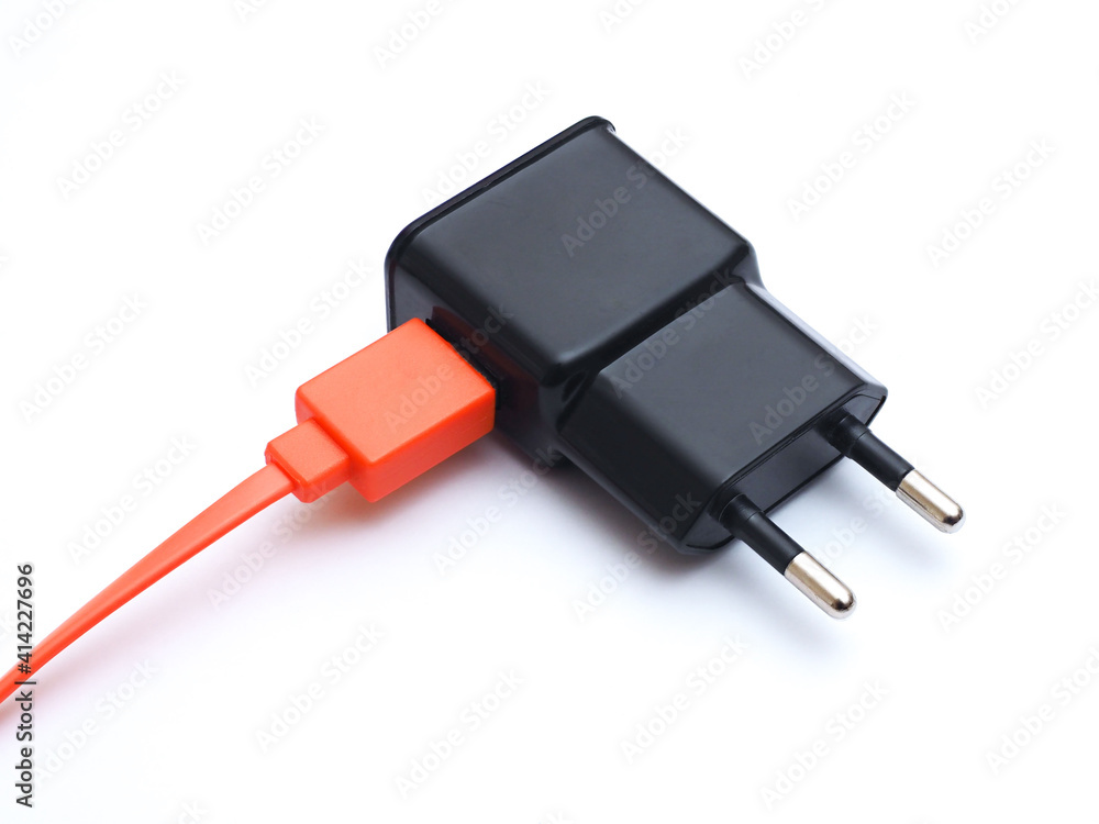 Charging adapter with orange USB cable on white background. Charging adapter with orange USB cable on white background.
