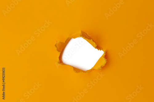 hole in orange yellow paper