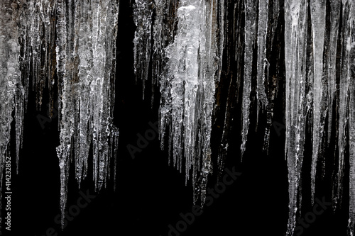 Obraz na płótnie Frozen icicles on black background w salonie