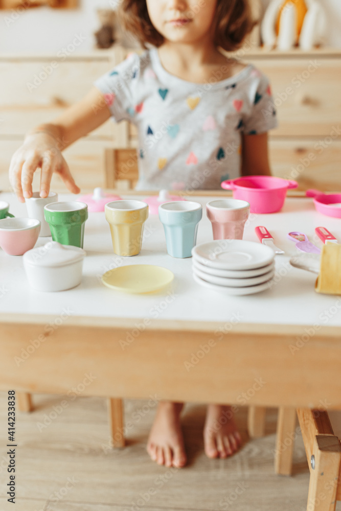 Little girl playing children tableware