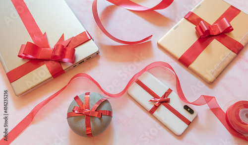 tech gifts wrapped with red gift bows