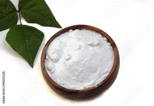 Sodium bicarbonate and  branch with fresh green leaves  isolated at white background.