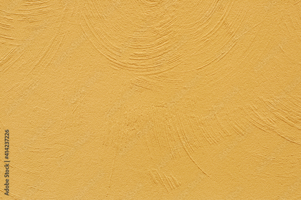 Obraz premium The texture of the plastered yellow wall. Decorative plaster using rounded stripes technique. Trending color