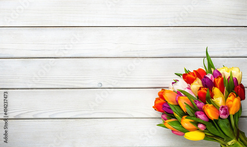 Colorful bouquet of tulips on white wooden background. Spring flowers. Greeting card with copy space for Valentine's Day, Woman's Day and Mother's Day. #414237473