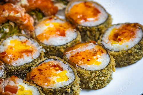 Hot fried sushi roll with salmon. Sushi menu. Japanese food. Hot fried sushi rolls on a white plate. Close-up