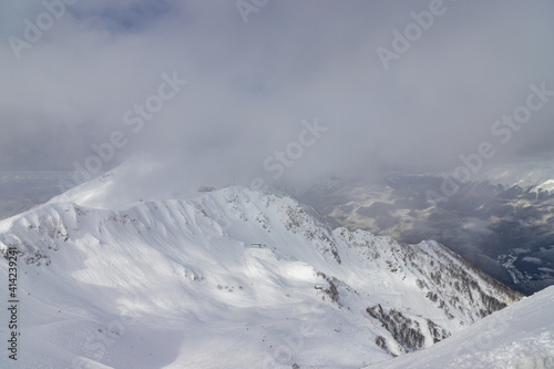Snow-covered mountains and ski slopes with clouds on background. Ski resort Roza Khutor. Sochi. Russia. © umike_foto