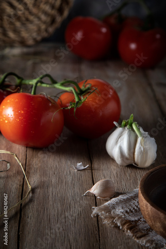 Red tomatoes and garlic on a rustic table
