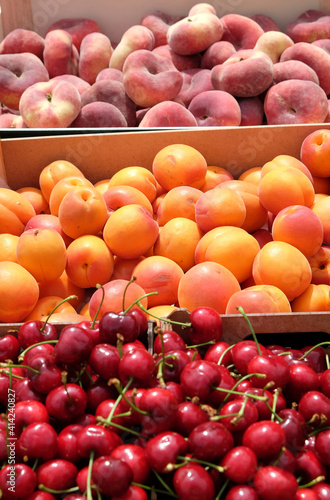 Früchte auf dem Markt: Pfirsiche, Aprikosen und Kirschen
