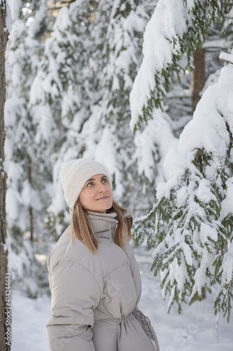 Young woman walking in snowy winter forest , enjoy the weather and wintertime.