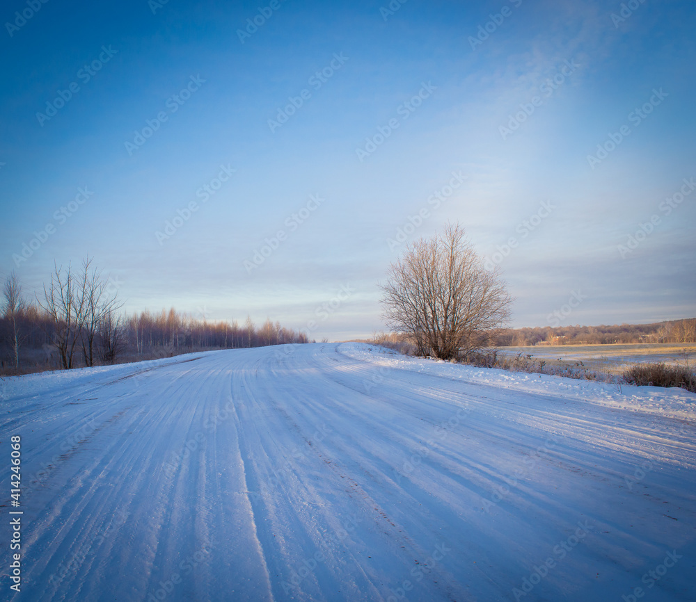 Obraz premium Road in the snow and blue sky.