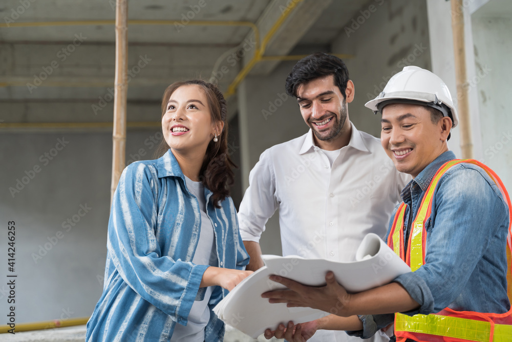 Obraz premium Asian couple checks the work of a contractor building a house for them.