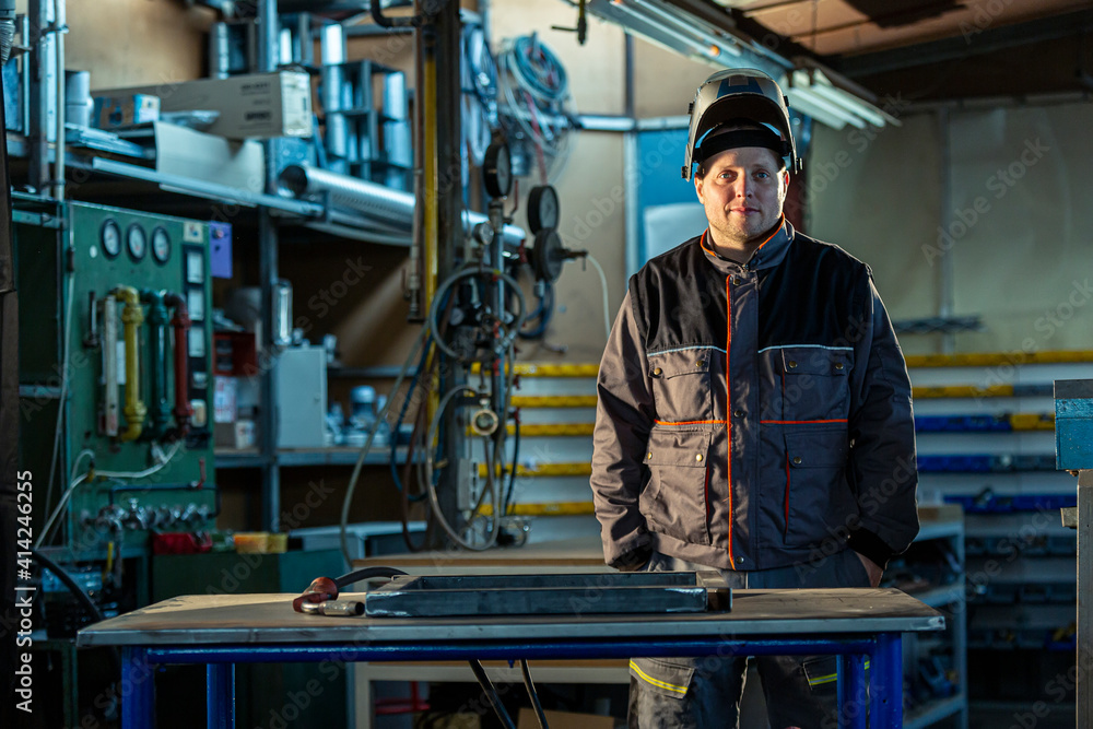 Portrait of a smiling welder posing in the factory Portrait of a smiling welder posing in the factory