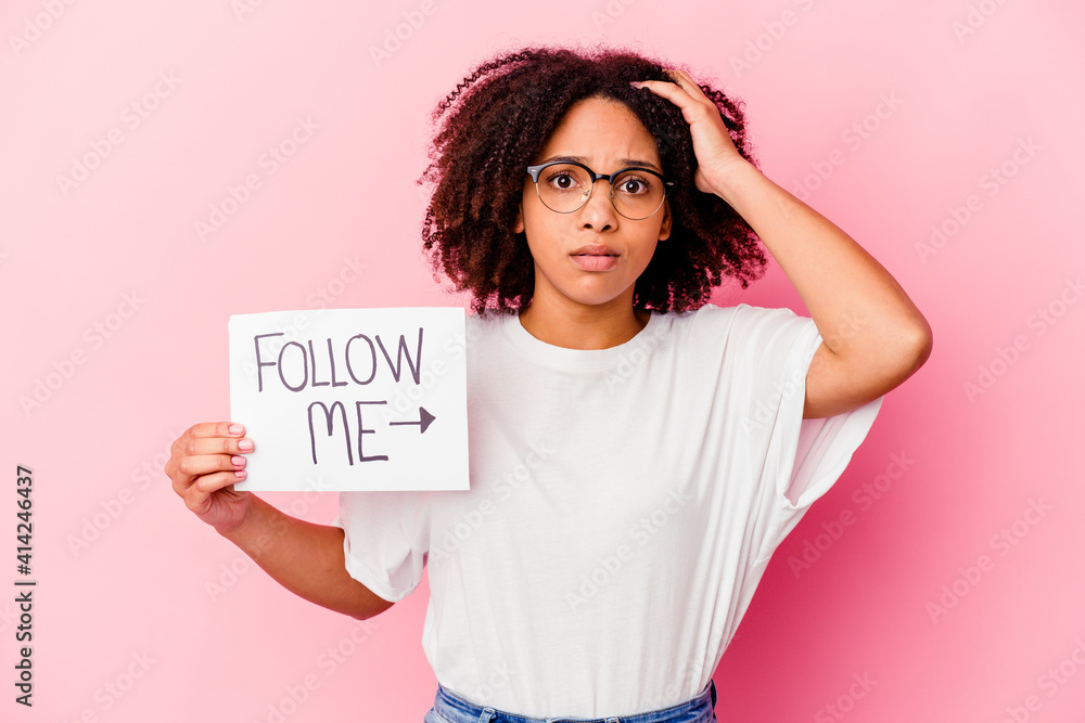 Young african american mixed race woman holding a follow me concept being shocked, she has remembered important meeting. Young african american mixed race woman holding a follow me concept being shocked, she has remembered important meeting.