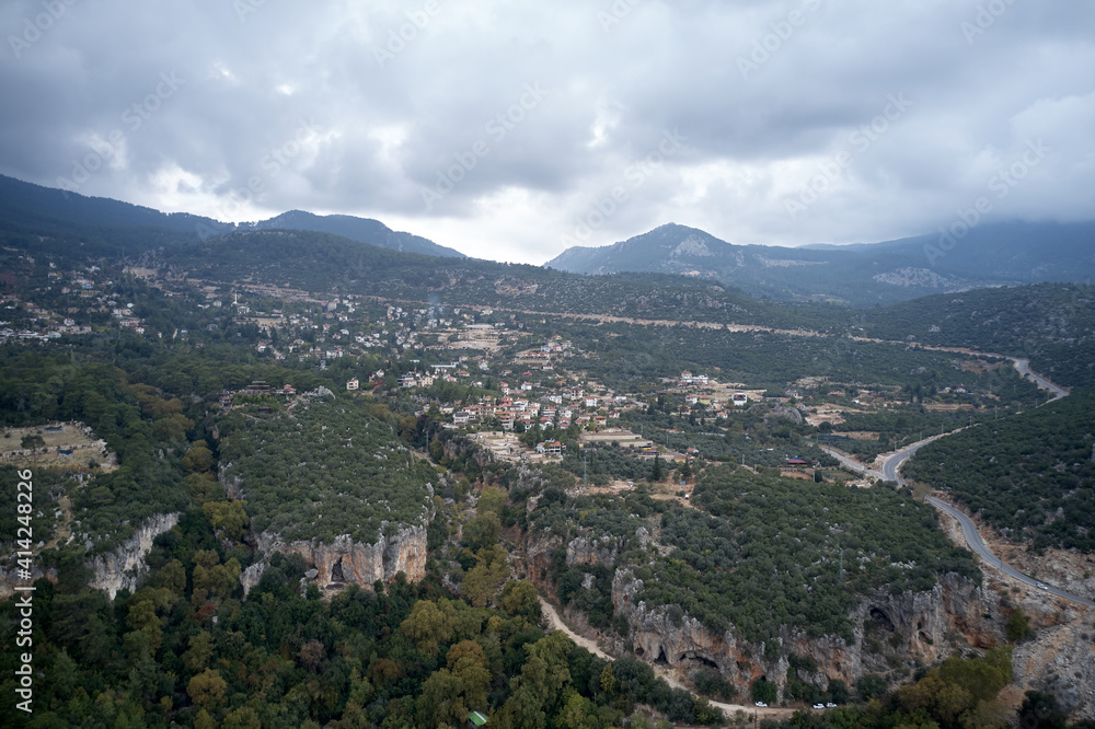 Aerial view of beautiful mountain valley with forest and village. Landscape view of mountain valley village.
