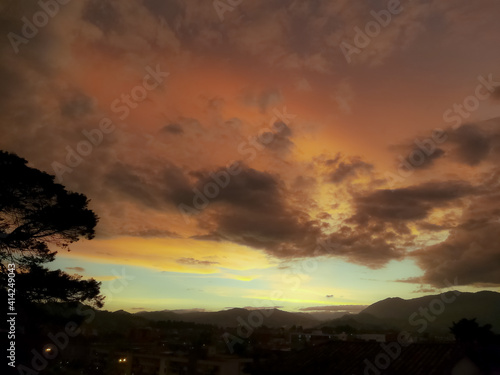 Panoramic view of a city or town during sunset. Sky in orange and blue tones.