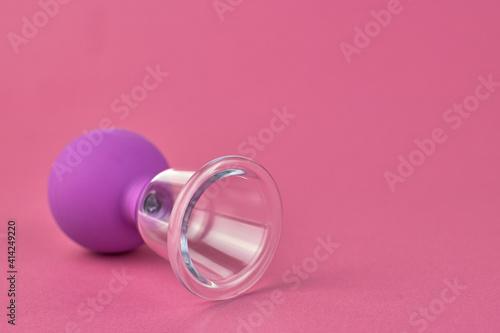 Cupping massage against cellulite. Massage jar on a pink background, close-up. The concept of body care against cellulite at home