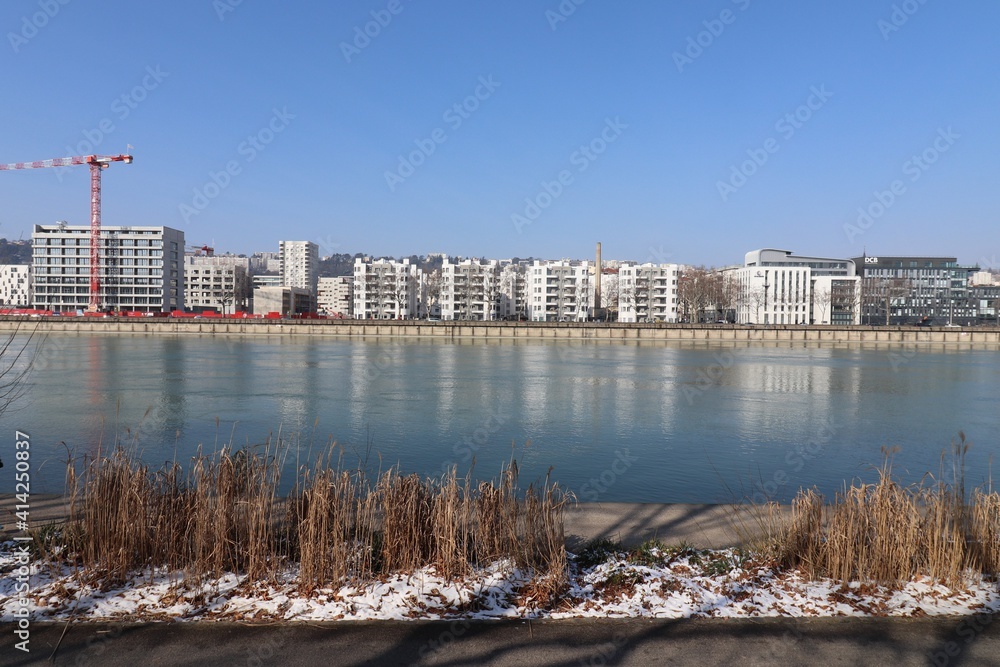 Fototapeta premium Immeubles sur le quai Perrache à Lyon le long du fleuve Rhône en hiver, ville de Lyon, département du Rhône, France