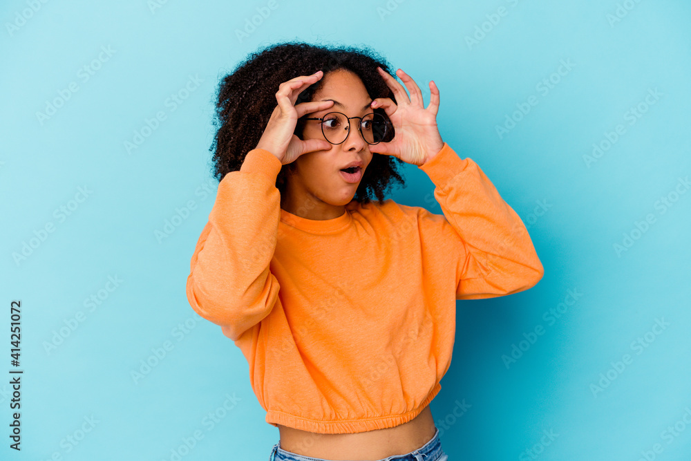 Young african american mixed race woman isolated keeping eyes opened to find a success opportunity. Young african american mixed race woman isolated keeping eyes opened to find a success opportunity.